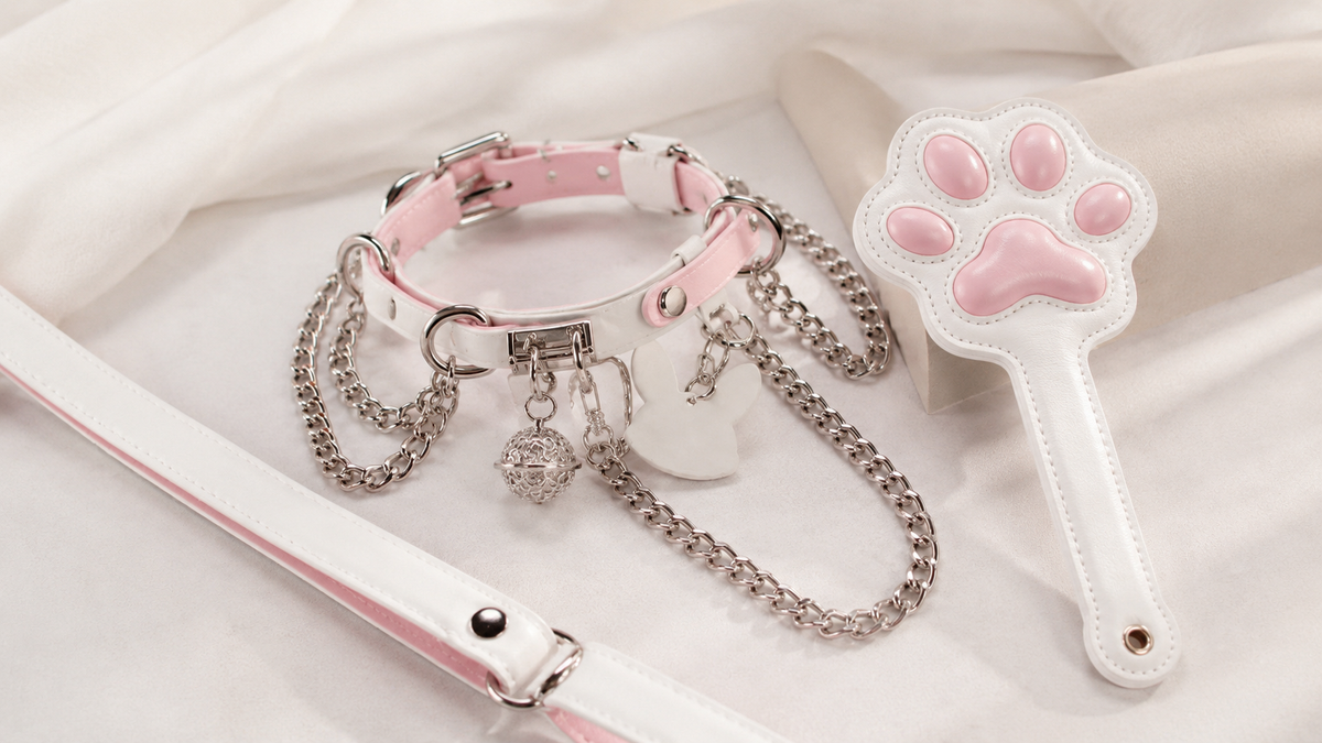 Pink and white ERA NOIR leather choker collar with layered chain charms, leash strap, and cat paw accessory
